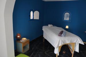 a blue bedroom with a bed and a table at Dar Mimouna Djerba in Tianest