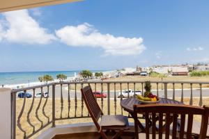 a table and chairs on a balcony with a view of the beach at Kahlua Bay Apartments in Hersonissos