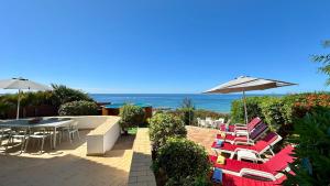 a patio with chairs and tables and an umbrella at Beira Mar - Private Pool - 7 Guests - Albufeira in Albufeira