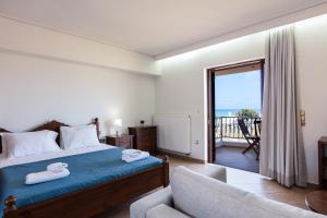 a bedroom with a bed and a chair and a balcony at Kahlua Bay Apartments in Hersonissos +42 photos