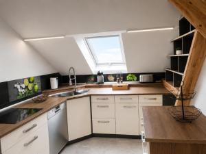 a kitchen with white cabinets and a window at Bad Aibling City Apartment - Pano in Bad Aibling