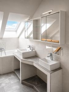 a white bathroom with two sinks and a tub at Bad Aibling City Apartment - Pano in Bad Aibling +7 photos