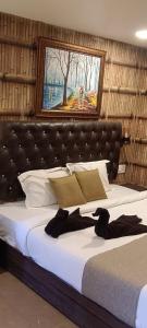 a bedroom with a large bed with a painting on the wall at Mountain Cottages Coorg in Madikeri