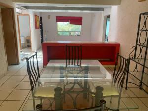 a glass table and two chairs in a room at Casa Tikul in Temixco +5 photos