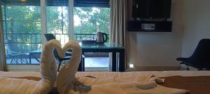a bed with a towel shaped like a swan on it at Mountain Cottages Coorg in Madikeri