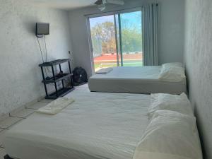 two beds in a room with a window at Casa Tikul in Temixco