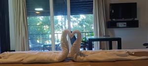 two towel swans sitting on a bed in a room at Mountain Cottages Coorg in Madikeri