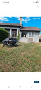 a picture of a house with a picnic table in the yard at Gîte teyssonniere in Usson-en-Forez
