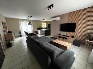 a living room with a couch and a flat screen tv at La Parenthèse de Quantilly in Quantilly