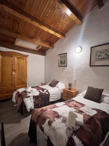 a bedroom with two beds and a wooden ceiling at ABELLETES - K31 DeuSol - Vall d'Incles - Soldeu Hut 6057 in Incles