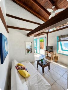 a living room with a white couch and a table at Zeisa House in Maresias