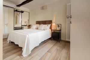 a bedroom with a white bed and a wooden floor at Villa Curte Nicia in Nizza Monferrato +76 photos