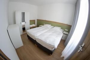 a bedroom with a white bed and a mirror at Lebeco Apartman in Kolárovo