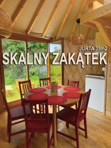 a dining room with a table and chairs in a room at Jurajskie Jurty in Golczowice +17 photos