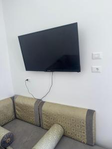 a flat screen tv on a wall above a couch at Venice Private Retreat Tripoli, Libya in Tripoli