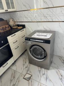 a kitchen with a washing machine and a microwave at Venice Private Retreat Tripoli, Libya in Tripoli