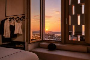 a bedroom with a window with a view of a city at Enorme EOS Santorini - Adults Only in Pyrgos