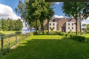 a large lawn in front of a house next to the water at Nautica Resort in Giżycko