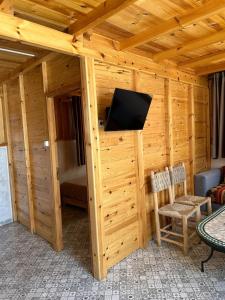 a wooden cabin with a tv on a wall at Blue Drift in Imsouane