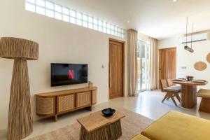 a living room with a flat screen tv on a wall at Villa Candi - Stylish Tropical Pool Villa in Ungasan