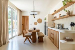 a kitchen with a wooden table and a table at Villa Candi - Stylish Tropical Pool Villa in Ungasan
