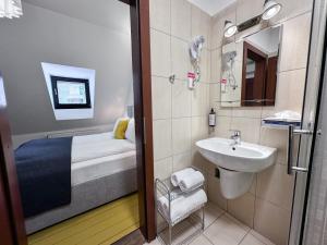 a small bathroom with a sink and a bed at Pensiunea Gasthaus Alte Post in Sighişoara +84 photos