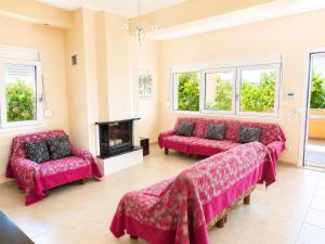 a living room with red couches and a fireplace at Angela's House in Nea Plagia +6 photos