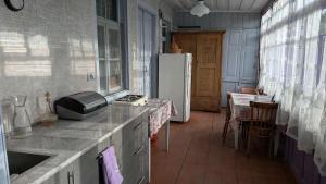 a kitchen with a refrigerator and a table with chairs at Lilac Orbeti - Cool Climate Country House Near Tbilisi in Pantiani