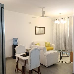 a living room with a couch and a table and chairs at Zurilyn Crib in Malindi