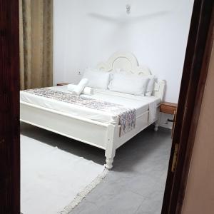 a white bed with white sheets and pillows on it at Zurilyn Crib in Malindi