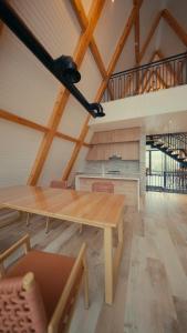 a dining room with a wooden table and a staircase at August Suites & Chalets in Khŭjakent Bekati