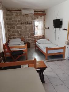 a room with two beds and a tv in it at Slavko in Hvar +6 photos