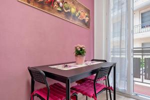a table with pink walls and a vase with flowers at La Casetta di G&G in Varese +15 photos
