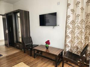 ein Wohnzimmer mit Tisch, Stühlen und Fernseher in der Unterkunft Draft Hotel Bir Billing At Landing Site in Bir