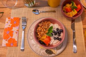 een kom met ontbijtgranen en fruit op een tafel bij Macana Eco Hotel in Montenegro