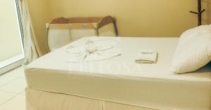 a white bed in a room with a pillow at Varanda Atlantica Casa Camocim enfrente a praia in Camocim