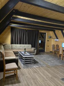 a living room with a couch and a table at ROMANIJA vikendice in Sarajevo