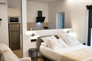 a bedroom with a bed with white pillows at Apartamentos Surya Home Suites in Conil de la Frontera