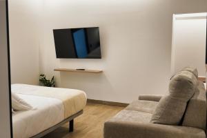 a living room with a couch and a tv at Apartamentos Surya Home Suites in Conil de la Frontera