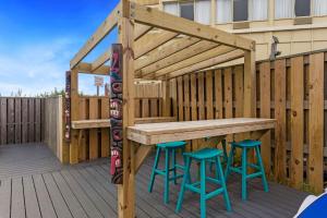 a wooden table and stools on a deck at 7000 - Serenity Sands in Whalebone