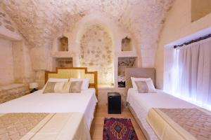 two beds sitting in a room with a wall mural at Old Town Urfa in Urfa