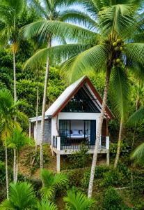 a small house in the middle of palm trees at Rainforest Mountain Escape - Lankagama in Deniyaya