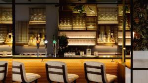 a bar with four chairs in front of a counter at Leonardo Boutique Hotel The Lancaster Amsterdam in Amsterdam +28 photos