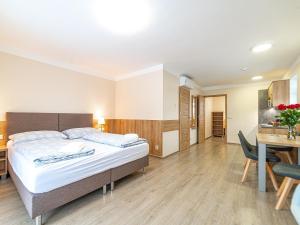 a bedroom with a bed and a table and chairs at Apartmány Superior Vila Věra in Rožnov pod Radhoštěm