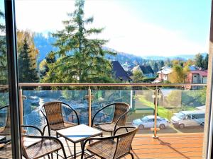 a balcony with chairs and a table on a deck at Apartmány Superior Vila Věra in Rožnov pod Radhoštěm