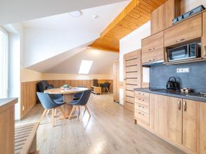 a kitchen and dining room with a table and chairs at Apartmány Superior Vila Věra in Rožnov pod Radhoštěm