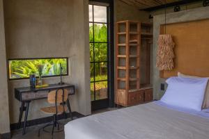 een slaapkamer met een bed, een bureau en ramen bij Macana Eco Hotel in Montenegro