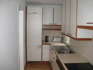 a kitchen with a sink and a white refrigerator at Ferienhaus Stemer Montafon in Schruns