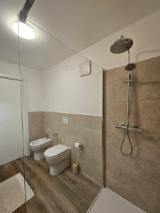 a bathroom with a toilet and a glass shower at Casa natura in Usini +35 photos