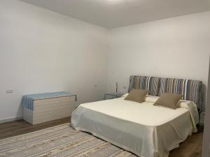 a white bedroom with a bed and a table at Casa natura in Usini